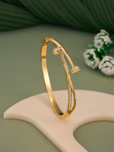 Gold bracelet with diamond accents on a green background
