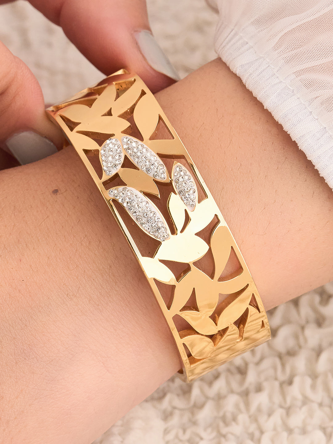 Gold bracelet with leaf design worn on a wrist