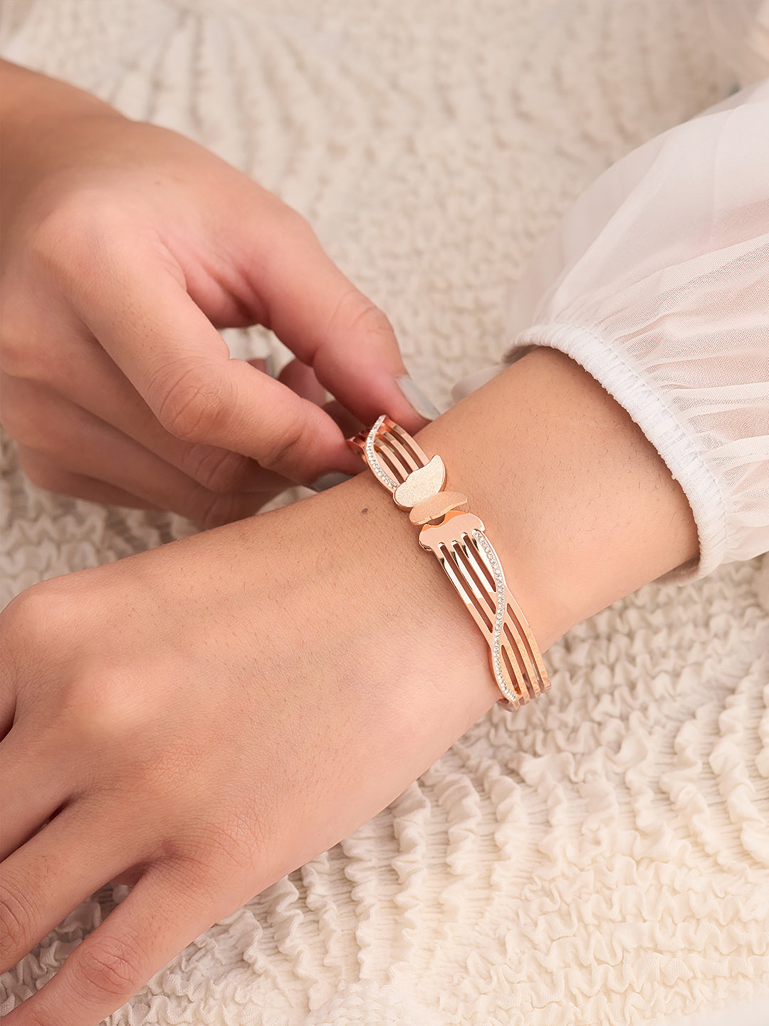 Person wearing a unique bracelet shaped like a fork on a textured surface