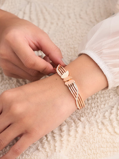 Person wearing a unique bracelet shaped like a fork on a textured surface